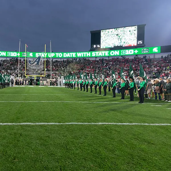 Flag squad standing on either side of endzone forming tunnel for players to run through