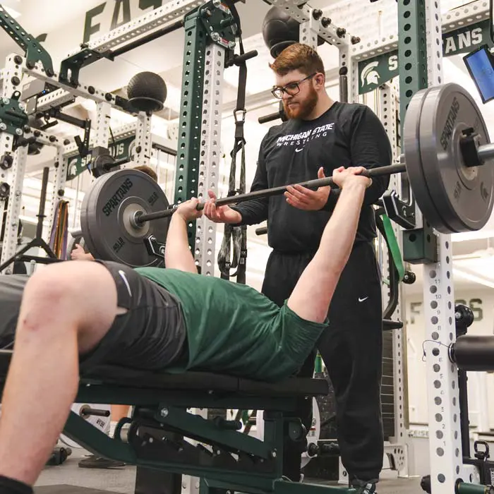 student-athletes lifting weights