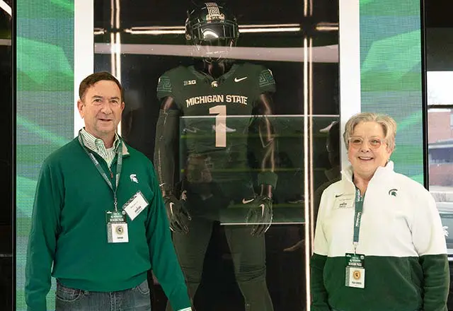 Ron and Lori Skover posing with football mannequin