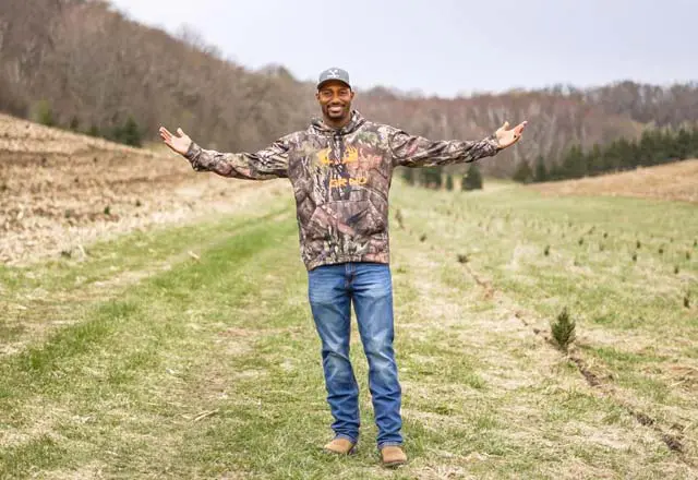 Trae Waynes standing in a field with arms stretched open