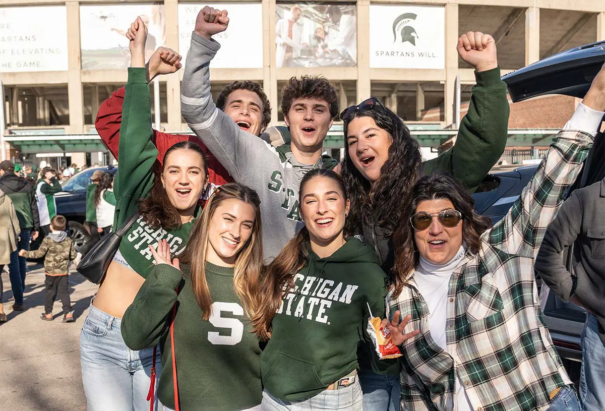 Students with arms up in the air